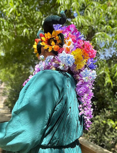 Various spring flowers, fruit, and wisteria with emerald horns and matching emerald ears. On thick velvet crocheted beanie in matching green.