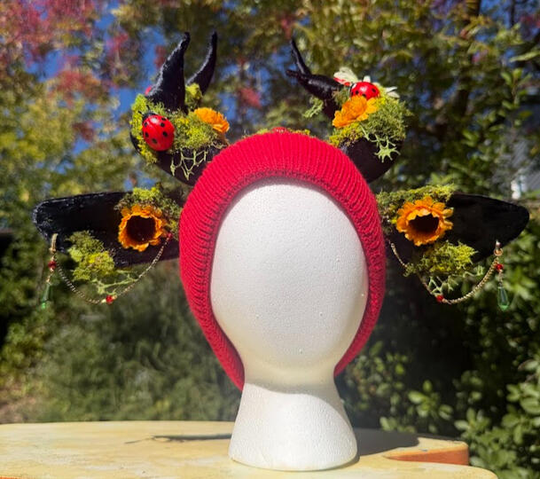 Red beanie (unlined) with black antlers and black slender doe ears. 5 ladybugs perch.