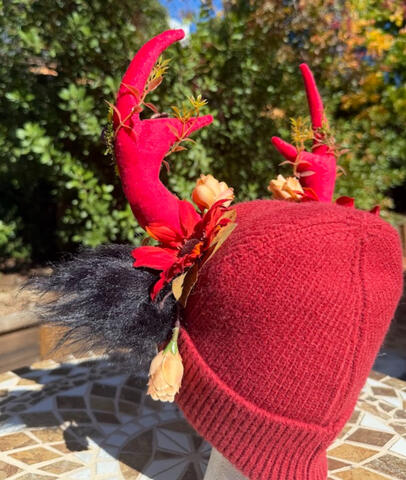 Bright red flowers peek behind the antlers.