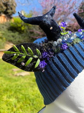 A vine strand sprouts from each ear, decorated with iridescent shiny beads on the ears and antlers. The antlers are slightly smaller than they are normally, around 8" in length.