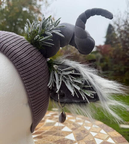 Two long silver spike piercings and O-ring earring with agate decorate the ears.