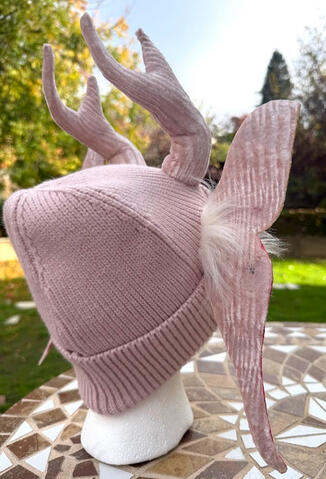 A tuft of white faux fur sprouts from each wing for a fuller moth-like effect.