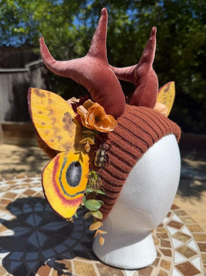 Upcycled chestnut brown beanie with matching brown mini antlers. Horns are poseable. This beanie has an inner cream sherpa lining. This beanie is slightly smaller than usual and would best suit a 19-21" head circumference.